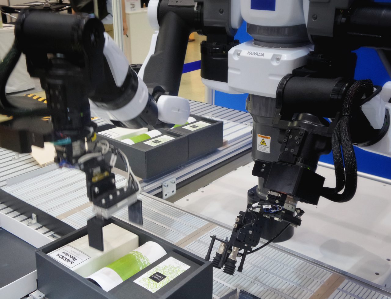 A photo of a robotic arm in a manufacturing plant with the Sahamid logo in the background.